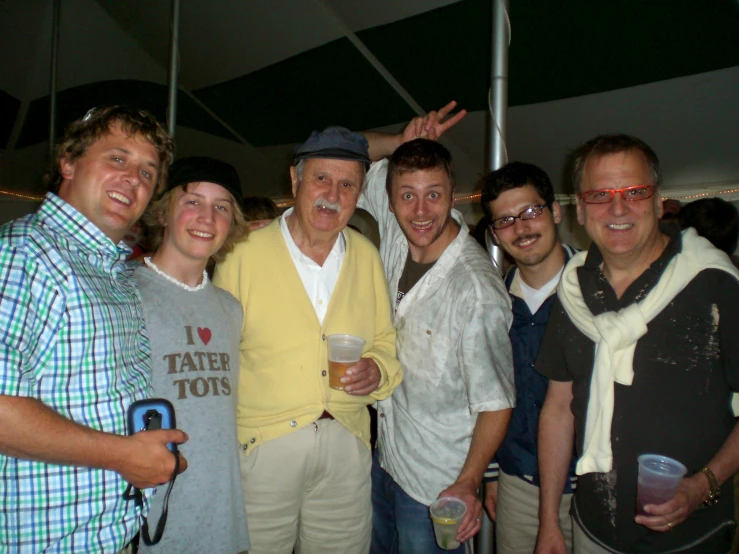 many men posing with glasses on at a party