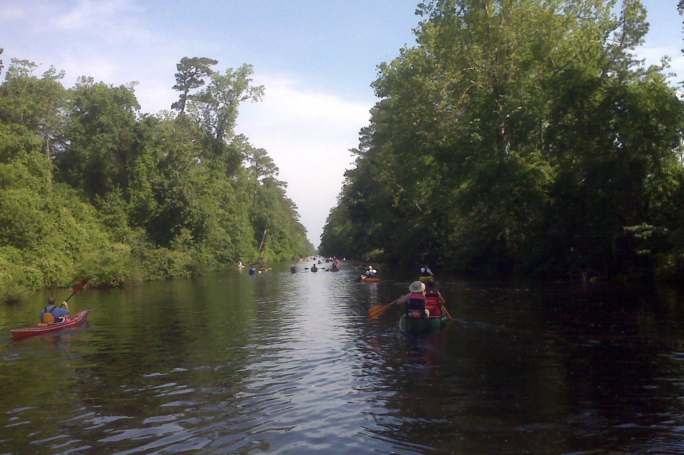 a group of people in canoes paddling down the river