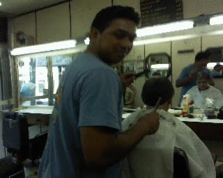 the man is getting his hair cut at the barber