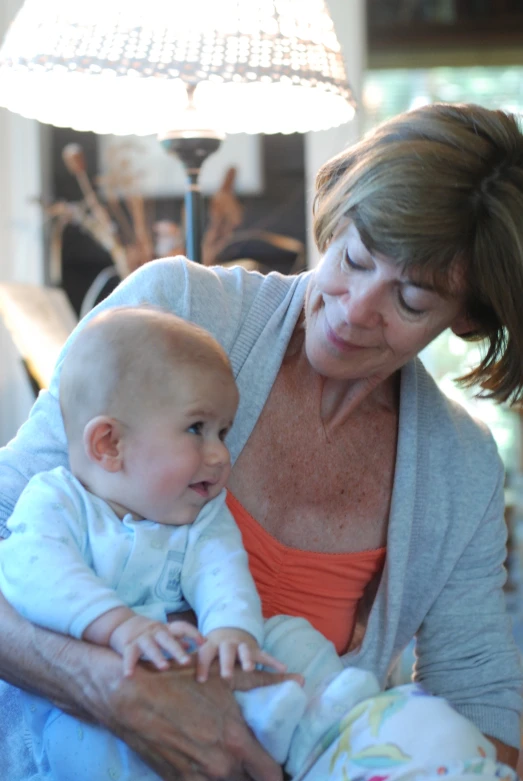 a woman holding a baby with an older man next to her