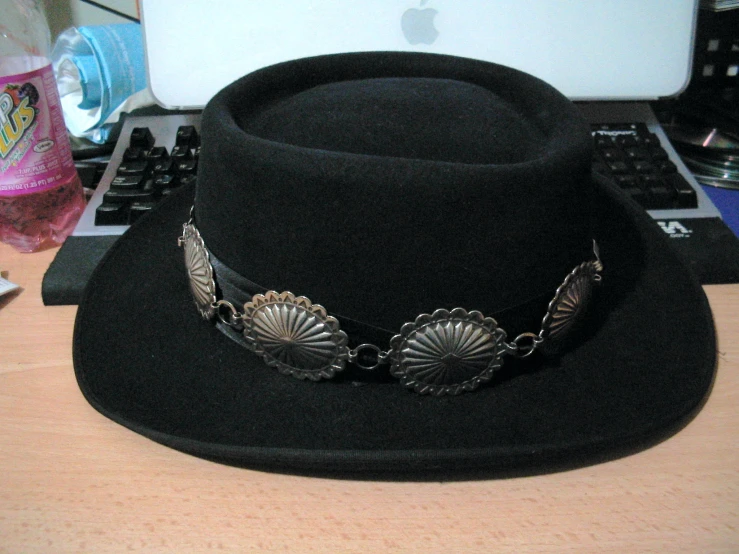 a hat on a desk next to a laptop