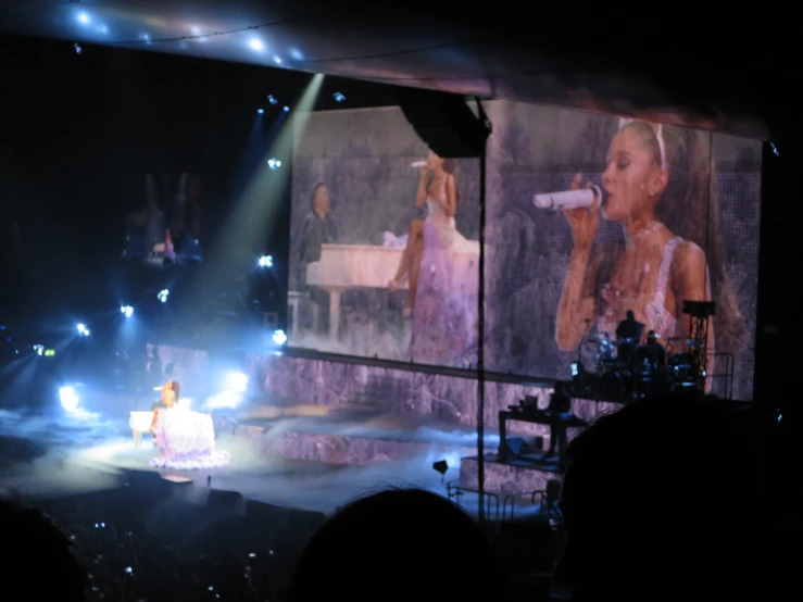 a screen showing pictures of two women on a stage