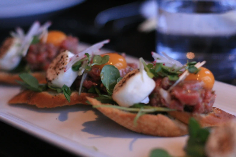 a plate topped with pieces of bread and toppings