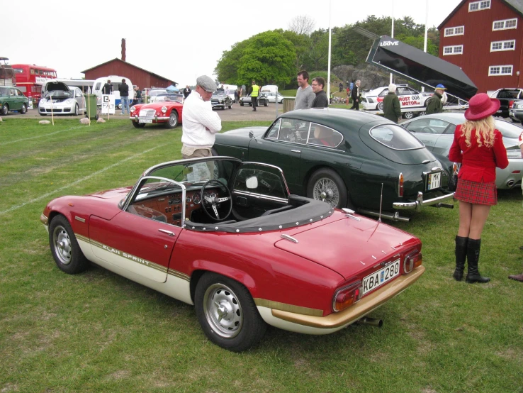 two people looking at cars in a field