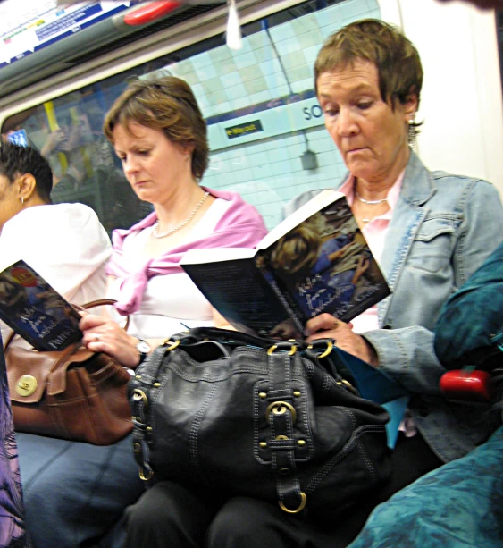 people sit together on a train, reading and traveling