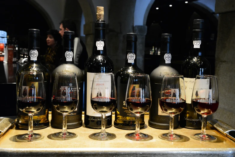 several glasses of wine lined up on top of a table