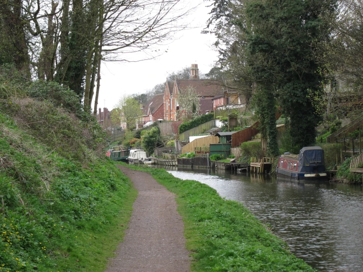 a canal running beside a lush green city