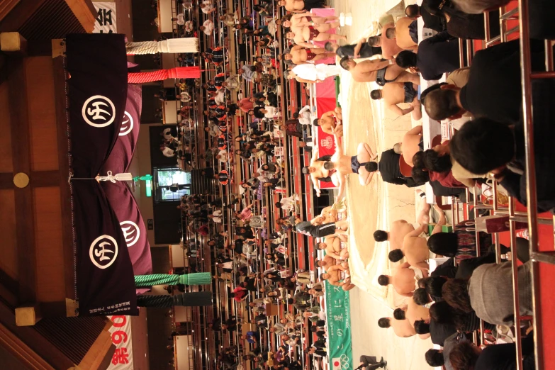 sumo wrestlers engaged in heated competition inside a crowd