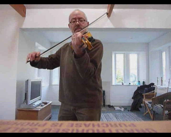 a man holding a violin in a room