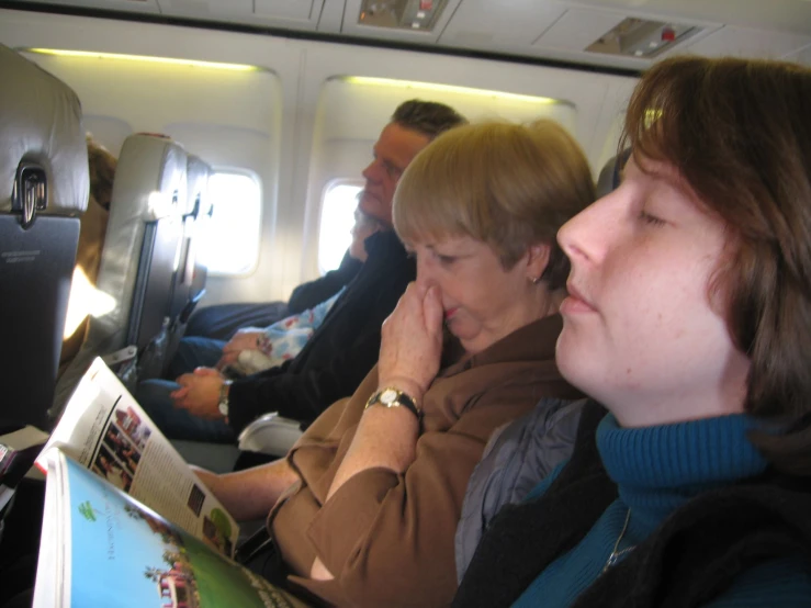 a man and woman are looking at the magazine