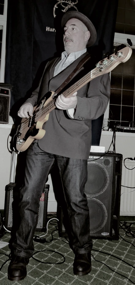 a man playing a guitar while wearing a hat