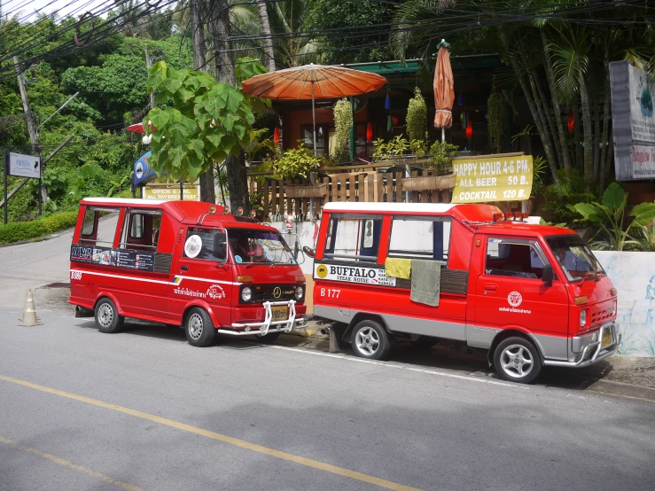 two red food trucks parked in front of a building