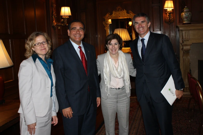 several people in suits and ties stand smiling