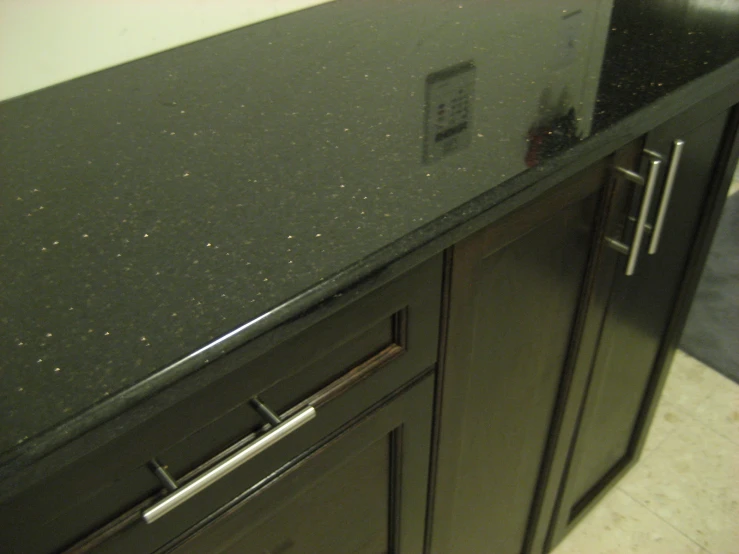 a close up of an kitchen counter that has dark cabinets