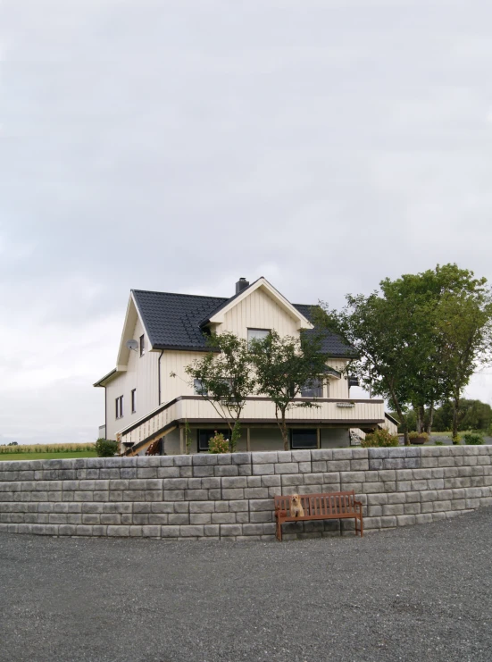 a large house sits next to a stone fence