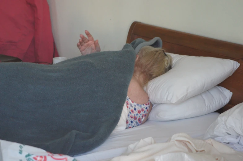 a toddler is laying in bed with some pillows