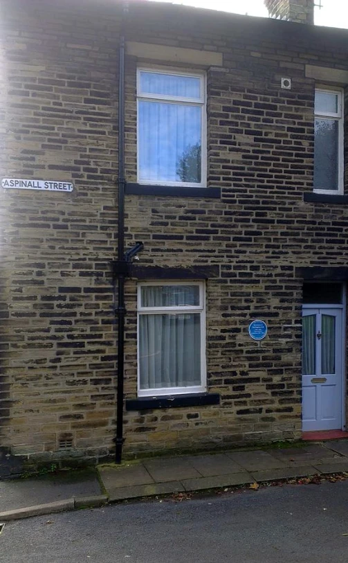 a small house with two windows sitting next to a street