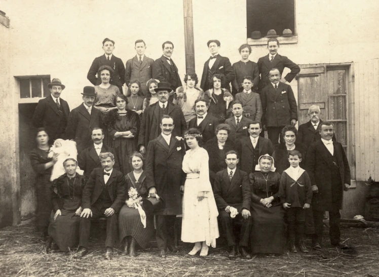 an old pograph of a group of people outside