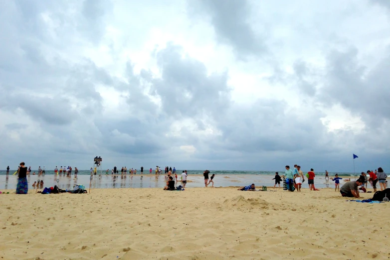 people at the beach and some are flying kites