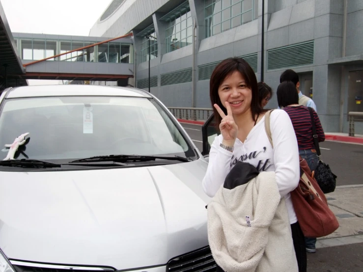 woman standing with a car on street with buildings