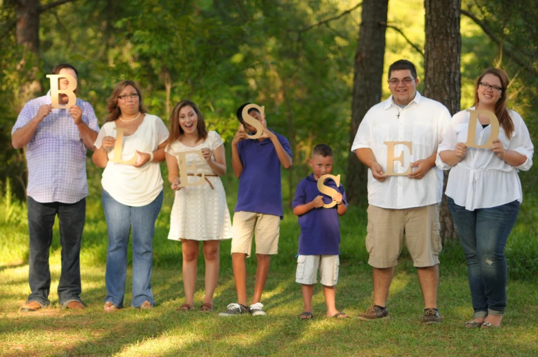 a family is posing for a po in front of a tree