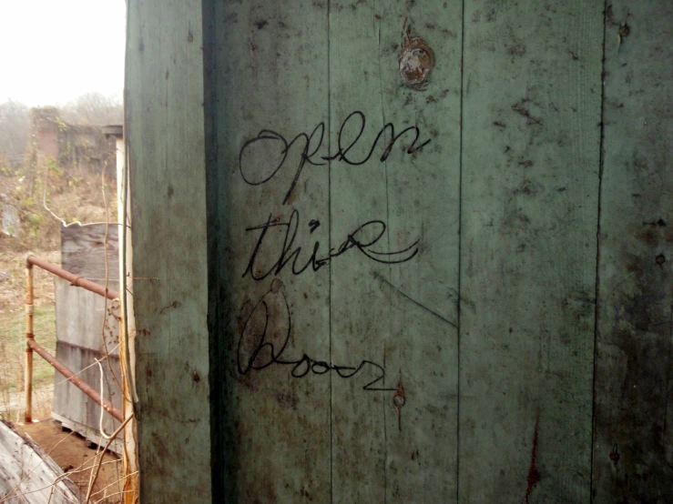 graffiti writing on a door that reads open to the outside