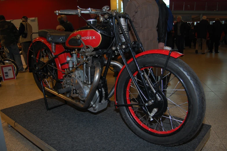 a red motorcycle sitting on display at an exhibit