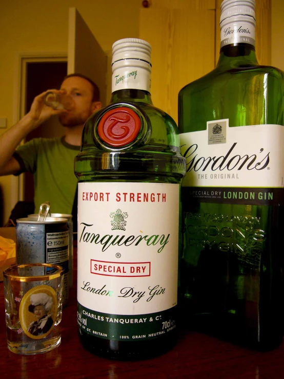 a man sitting at a table with two bottles of liquor