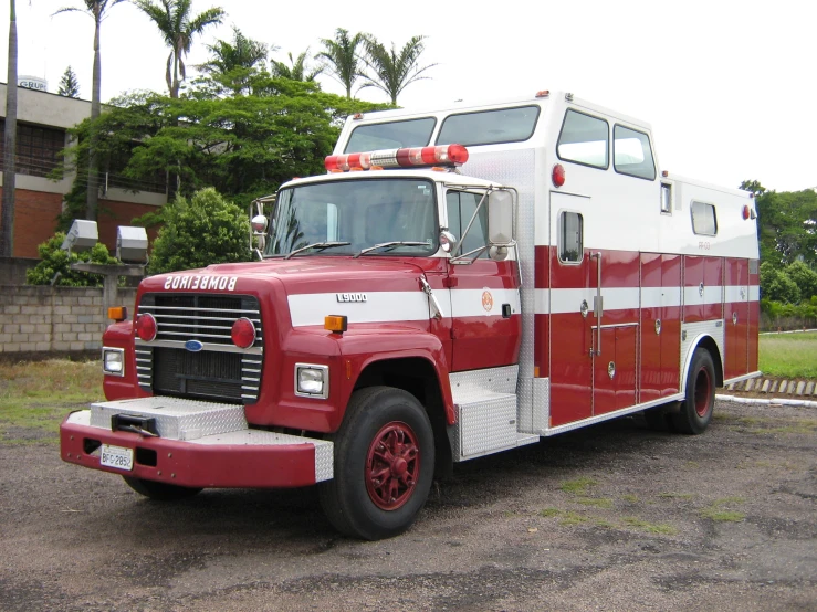 a red and white emergency truck in an open lot