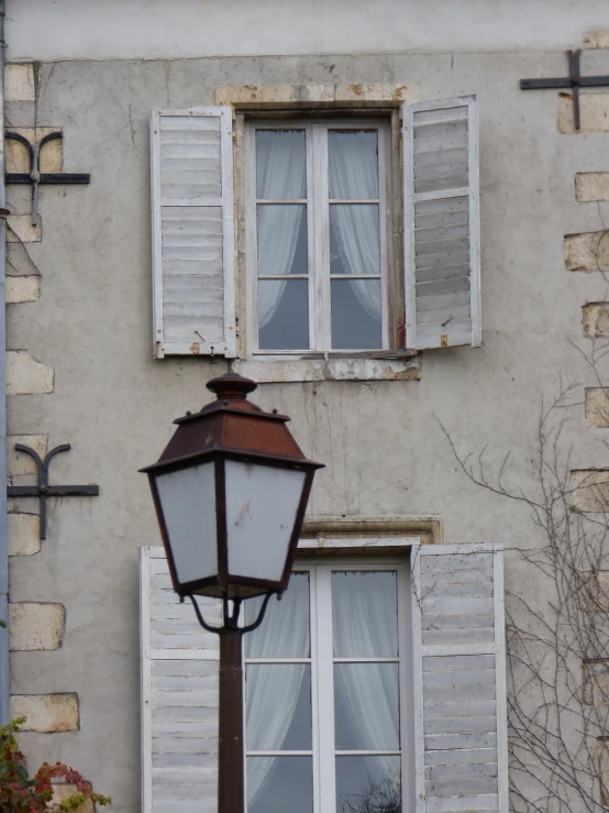 a lamp and window are in front of a brick building