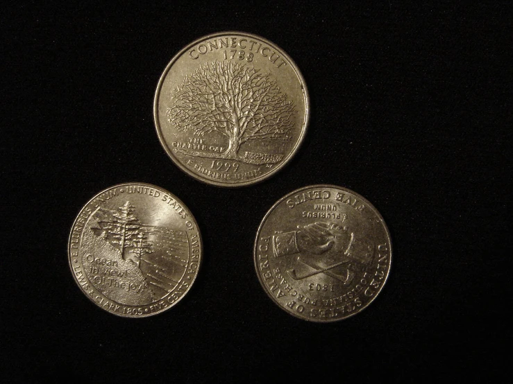 three quarters that are on a black background