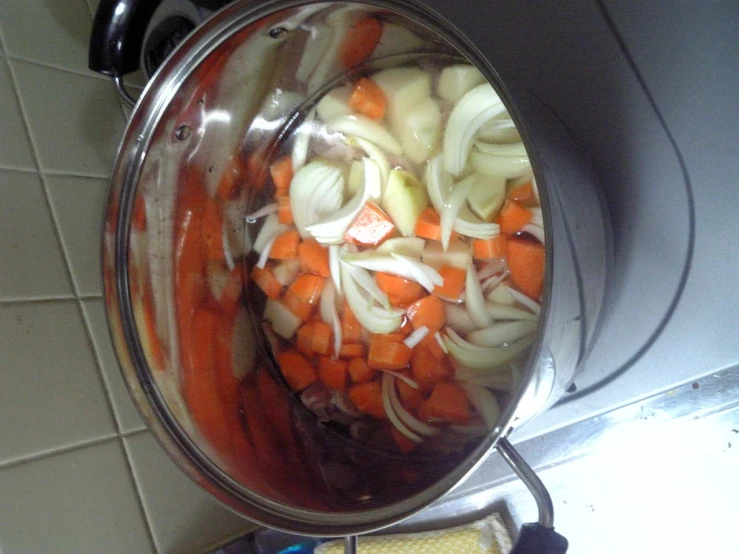 vegetables simmering in pot on countertop with knife