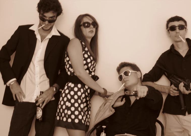 three men and a woman wearing dress and sunglasses