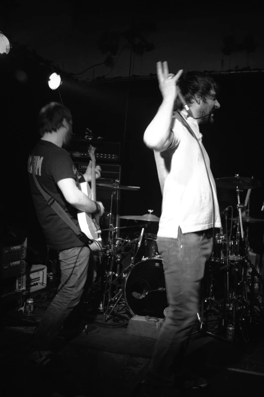 two young men are standing on the stage with their hands in the air