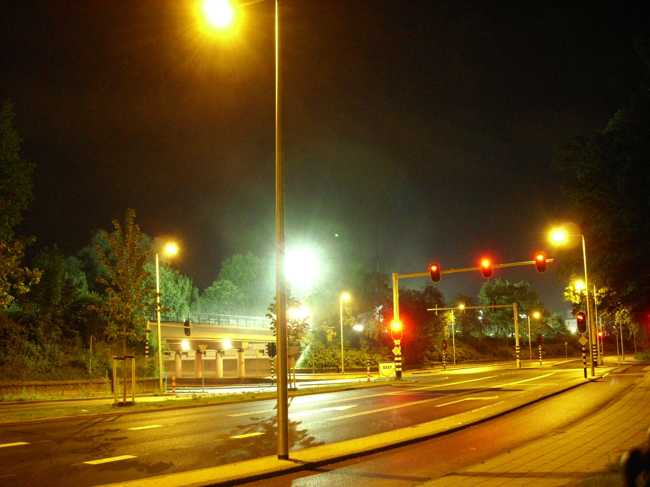 street lights shine at night next to a city street