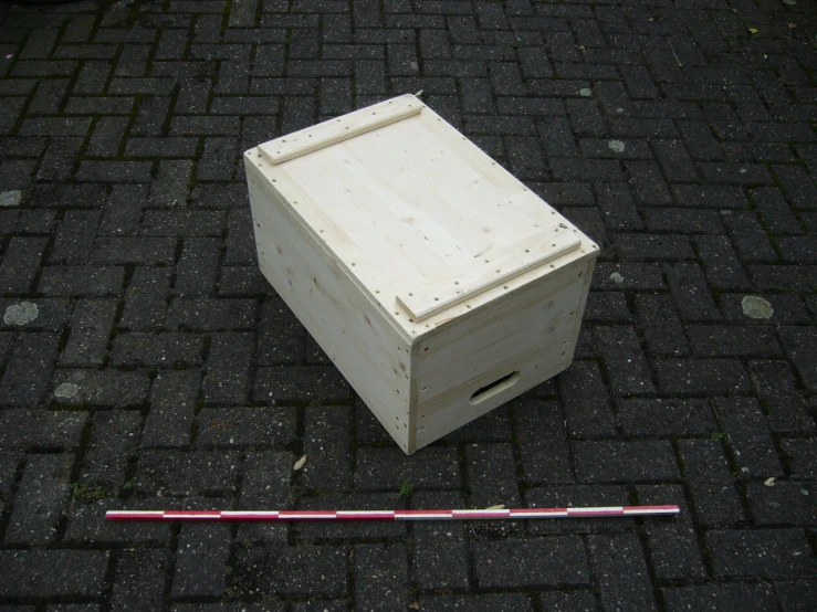 a wooden crate and some red stick on the ground