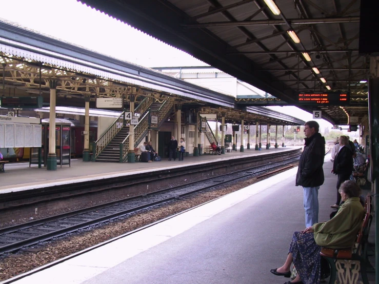 several people waiting on a platform for a train