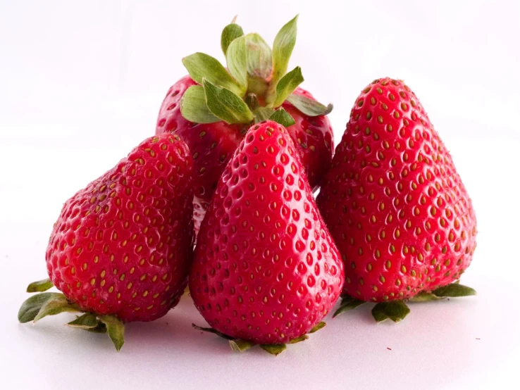 six strawberrys with some leaves on top of them