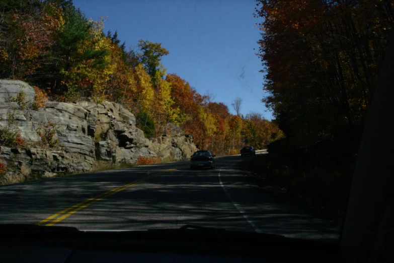 an open car window on a mountain side road with fall colors