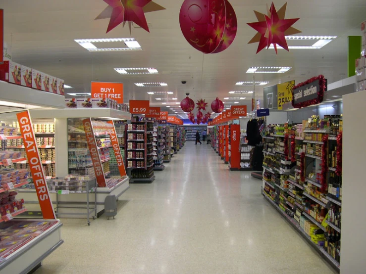 a market that has christmas decorations hanging from the ceiling