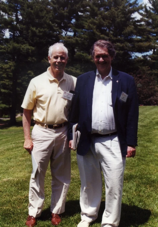 a couple of men standing on top of a lush green field