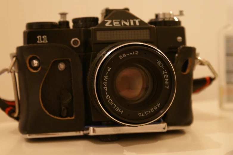 an old, black and brown camera with the lens open