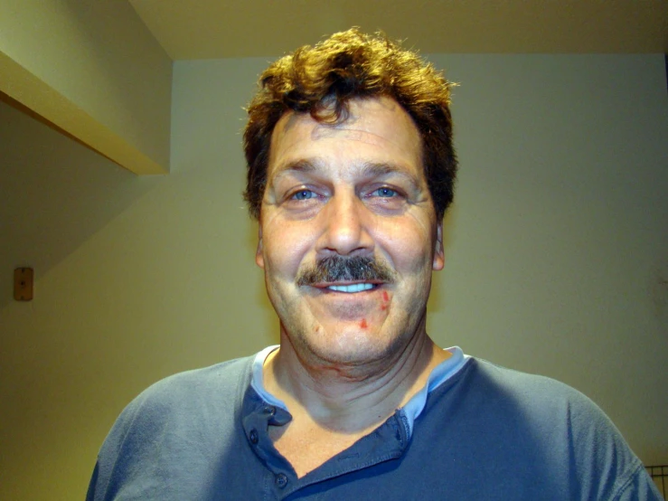 a smiling man with a fake mustache