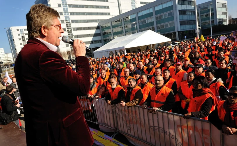 a man holding a microphone in front of an audience