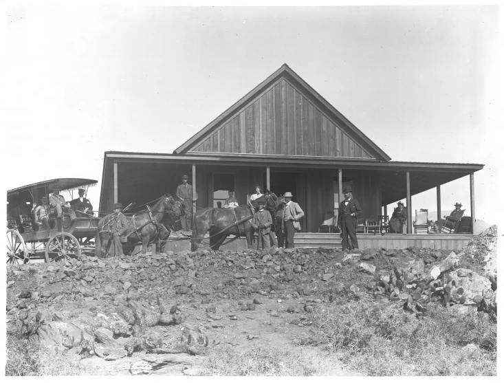 a couple of men standing next to a wooden barn