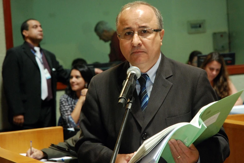 a man standing at a microphone in front of an audience