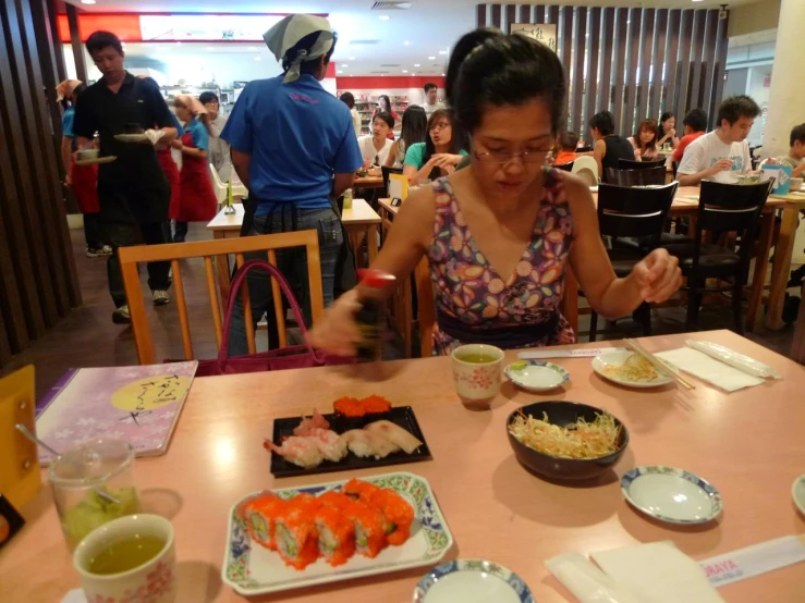a woman in a colorful dress is eating at a restaurant