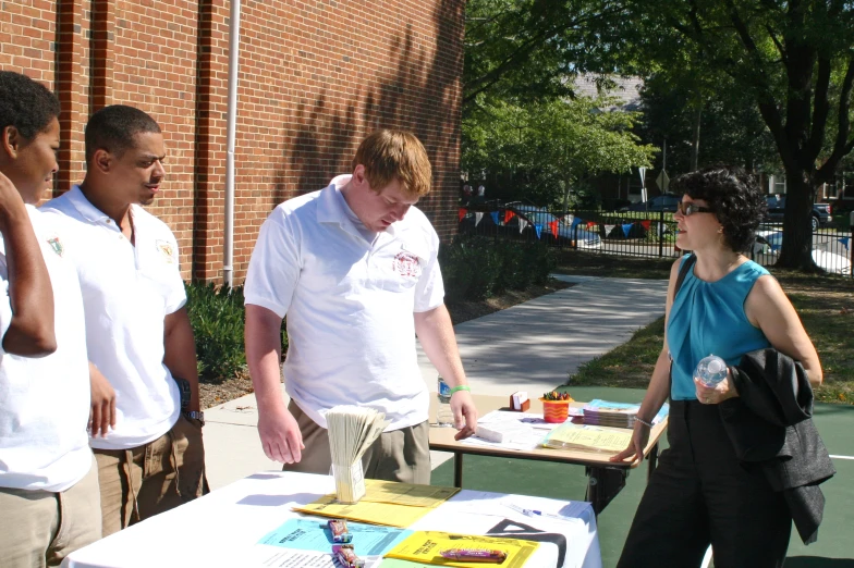 some people standing around a table near some buildings