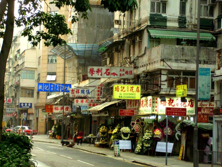 the people are walking down the street with signs on the buildings