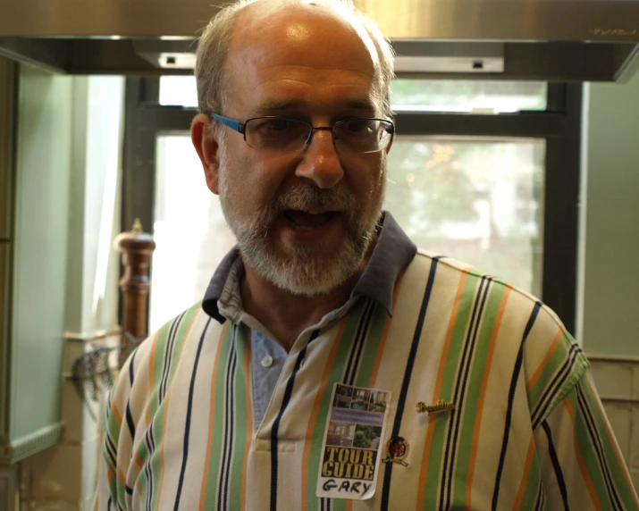 a man in striped shirt smiling in kitchen